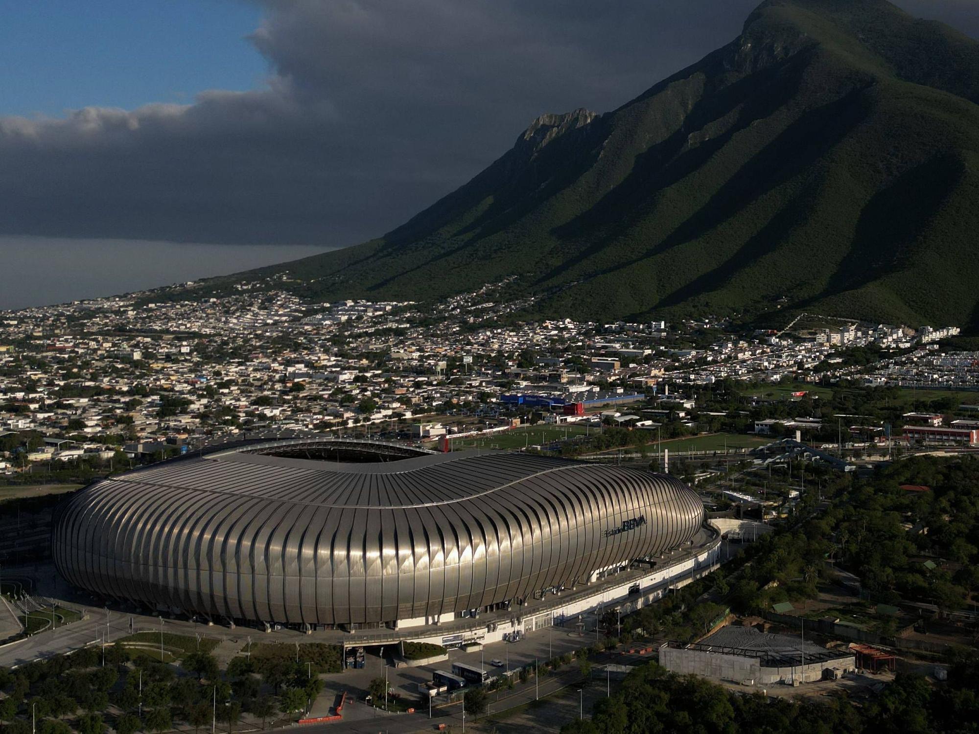 Ein futuristisches Stadion mit Blick auf eine Gebirgskette und eine Großstadt
