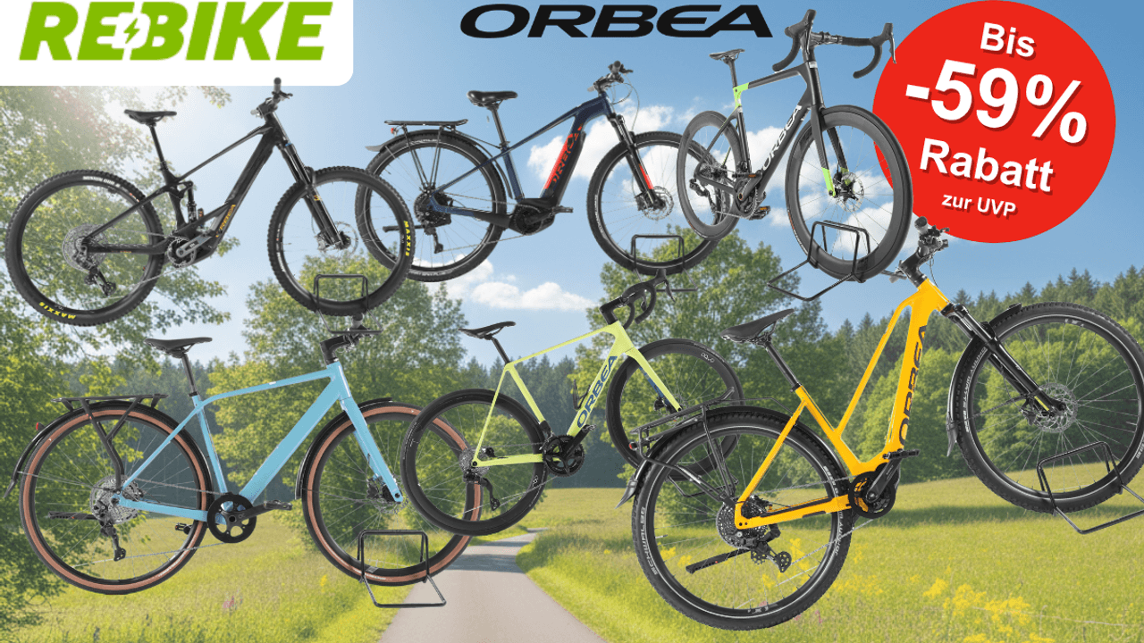 Mehrere refurbished Orbea E-Bikes verschiedener Kategorien – darunter E-Mountainbikes, Trekking-E-Bikes und Gravelbikes – vor einem sonnigen Radweg mit grüner Natur im Hintergrund. Logos von Rebike und Orbea sind zu sehen.