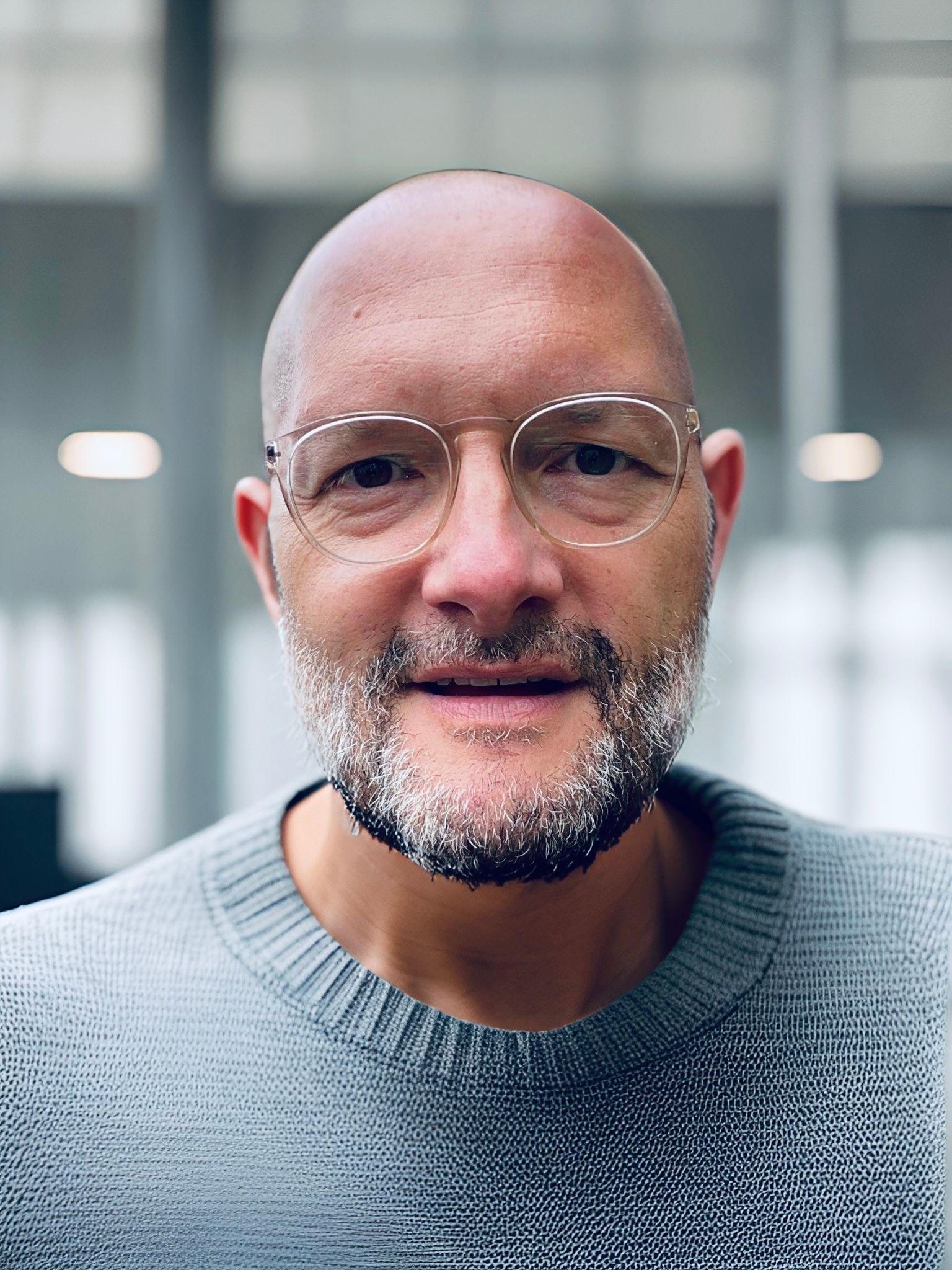 Ein Mann mit Brille und Glatze schaut in die Kamera. Es ist der Journalist Jo Failer