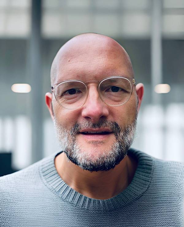 Ein Mann mit Brille und Glatze schaut in die Kamera. Es ist der Journalist Jo Failer