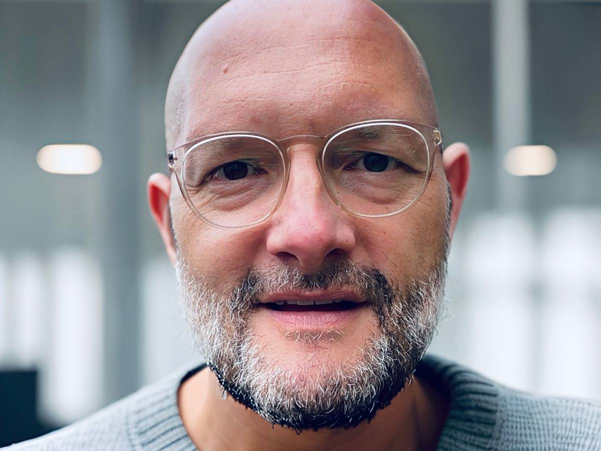 Ein Mann mit Brille und Glatze schaut in die Kamera. Es ist der Journalist Jo Failer