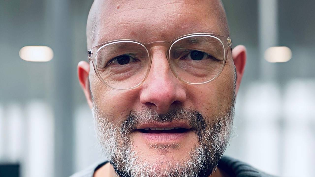 Ein Mann mit Brille und Glatze schaut in die Kamera. Es ist der Journalist Jo Failer