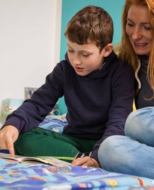 Mutter und Sohn schauen in ein Buch