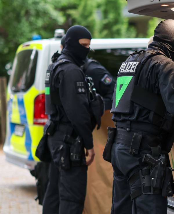 Vermummte Polizisten verlassen bei einem Einsatz ein Gebäude mit sichergestellten Gegenständen. (Symbolfoto)