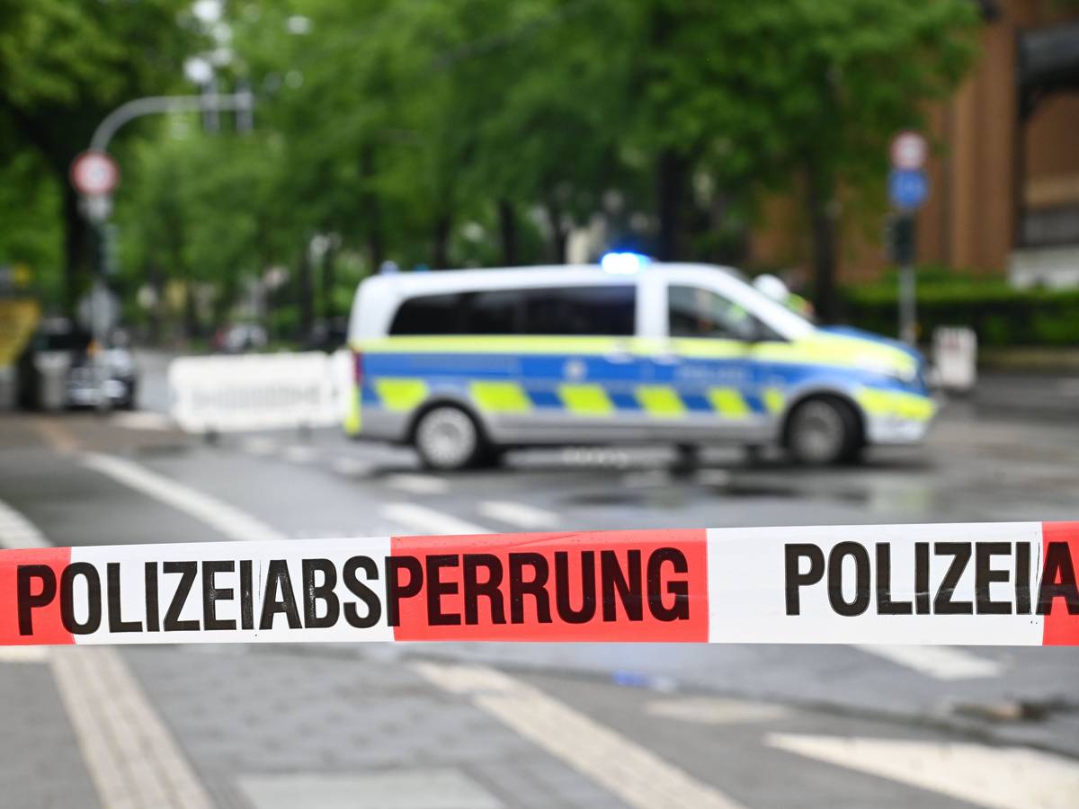 Die Polizei hat eine Straße mit Flatterband abgesperrt, im Hintergrund steht ein Polizeifahrzeug.