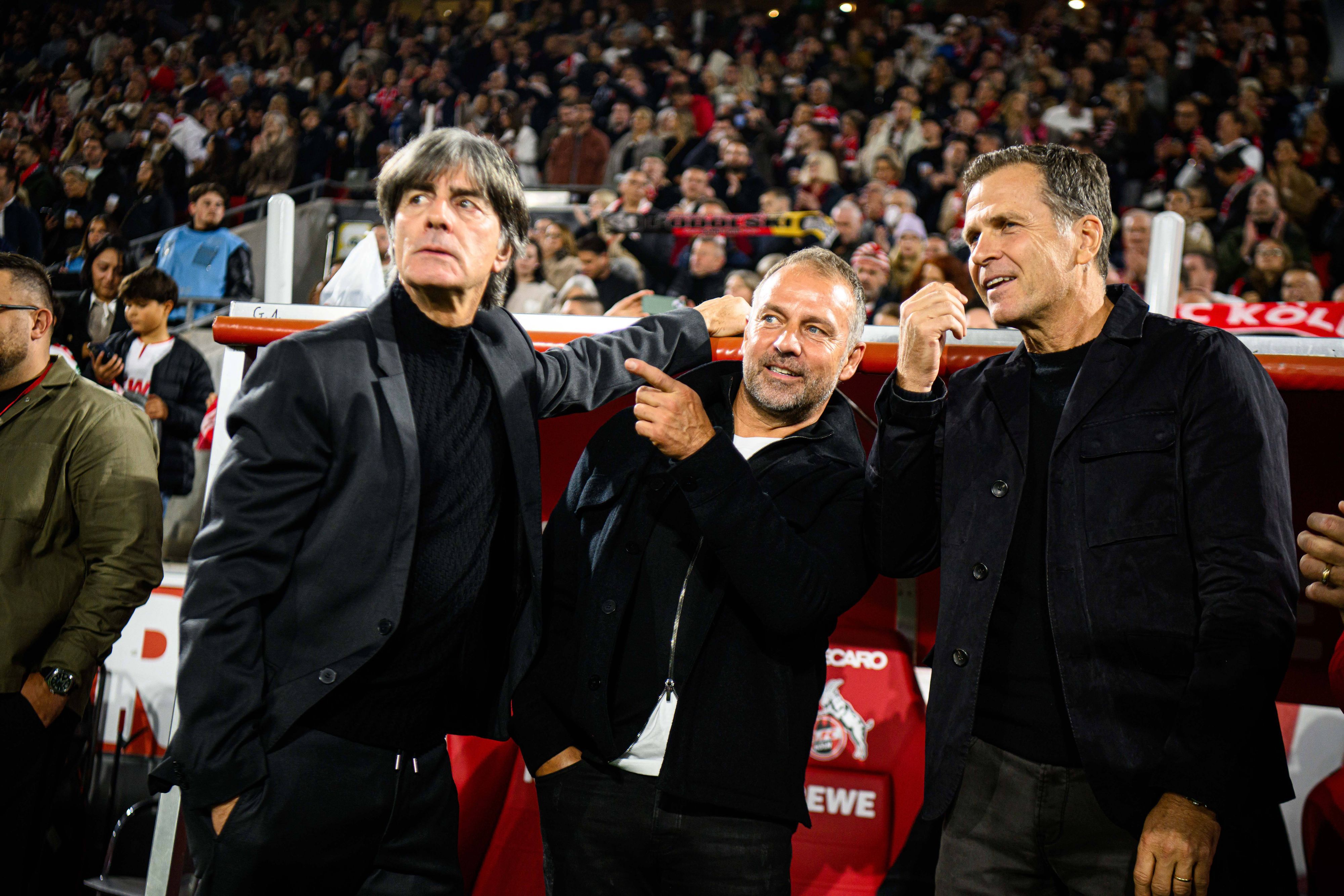 Joachim Löw, Hansi Flick und Oliver Bierhoff stehen vor der Trainerbank.