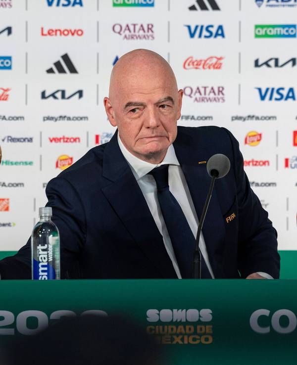 FIFA-Präsident Gianni Infantino sitzt bei einer Pressekonferenz vor einem Mikrofon.
