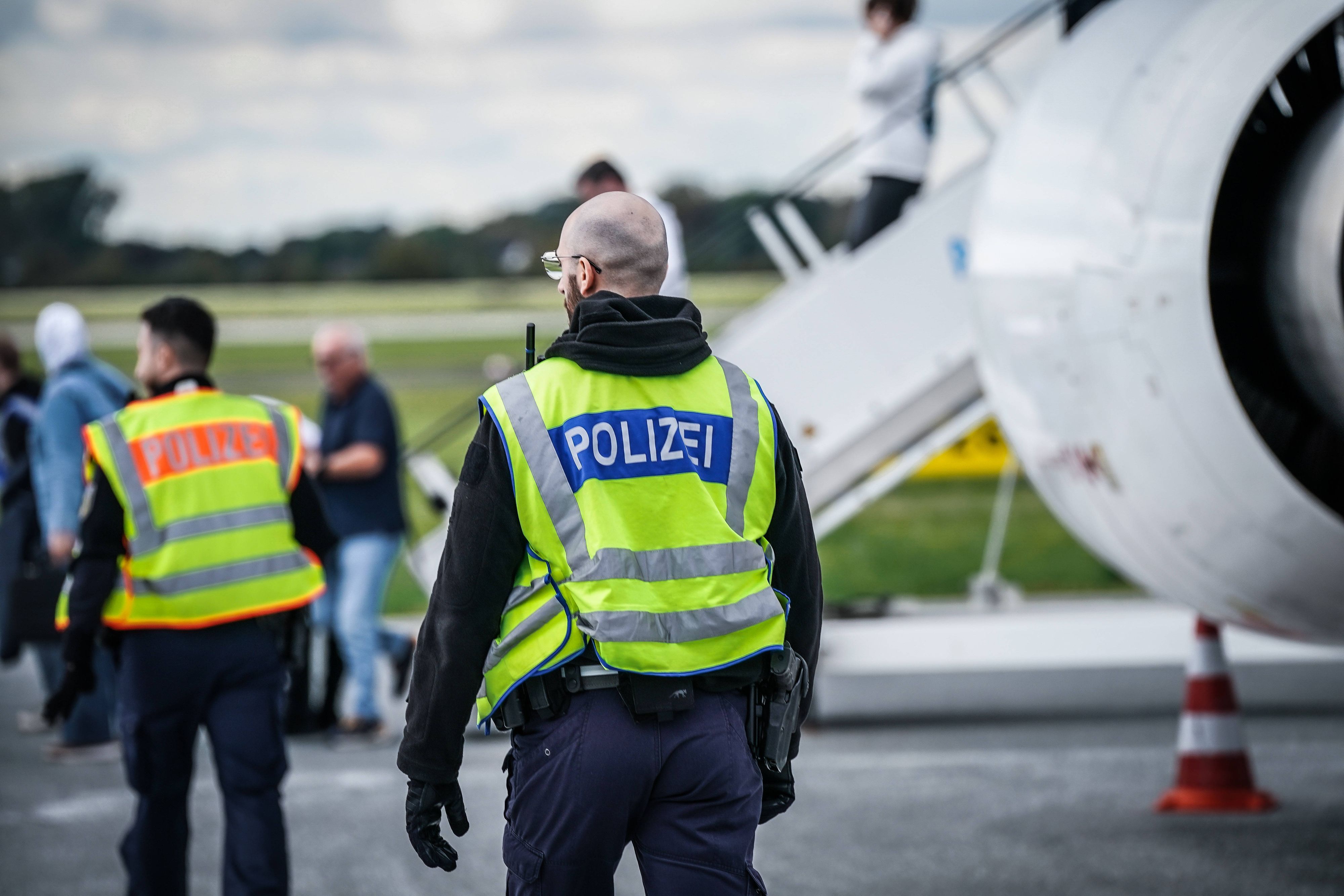 Polizisten und Personen am Flughafen