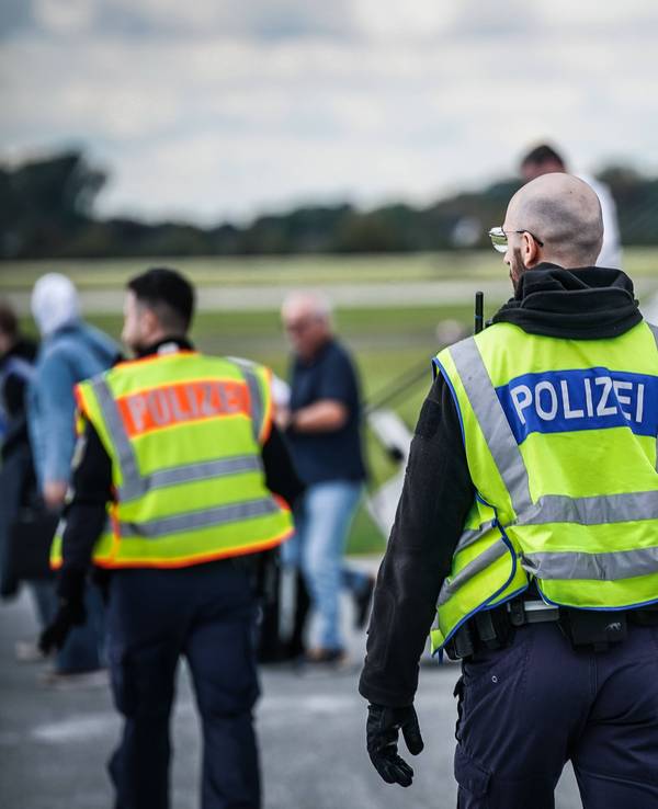 Polizisten und Personen am Flughafen