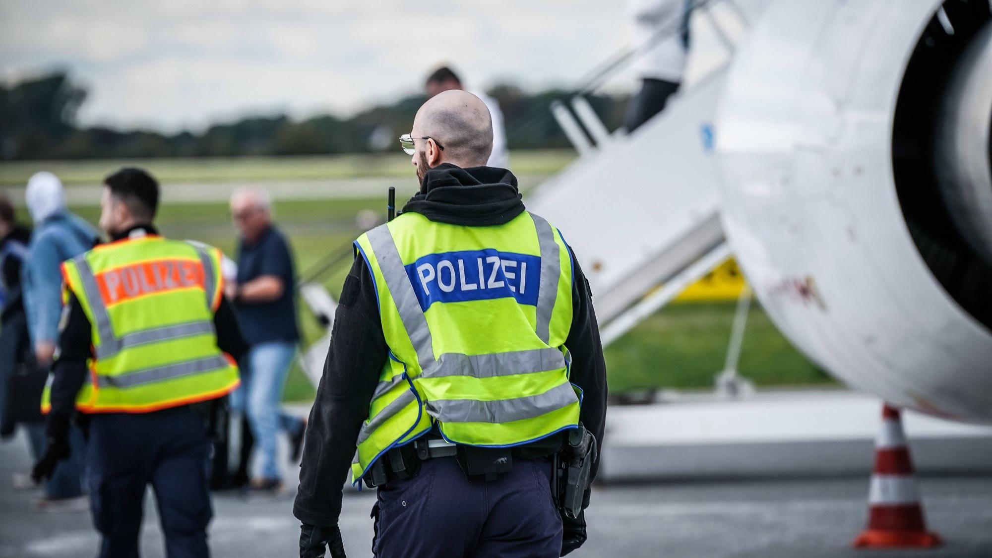 Polizisten und Personen am Flughafen