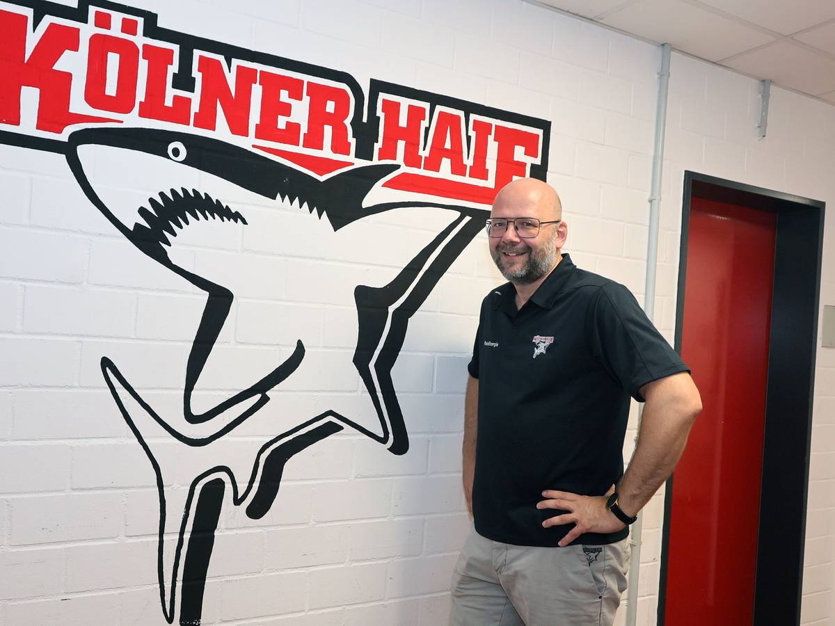 Philipp Walter, Geschäftsführer der Kölner Haie vor dem Klublogo.