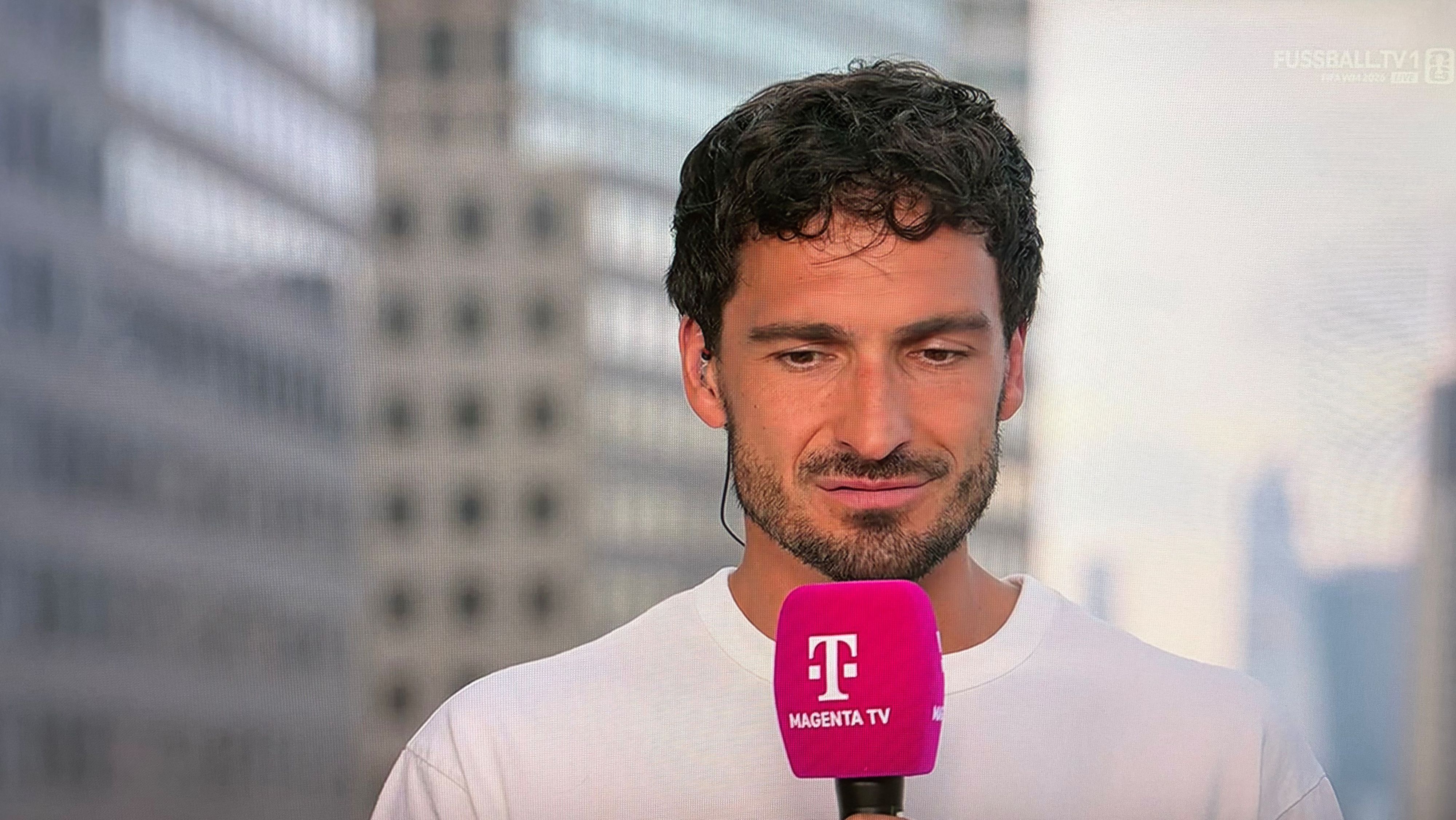 Mats Hummels hält bei einer TV-Übertragung ein Mikrofon in der Hand.
