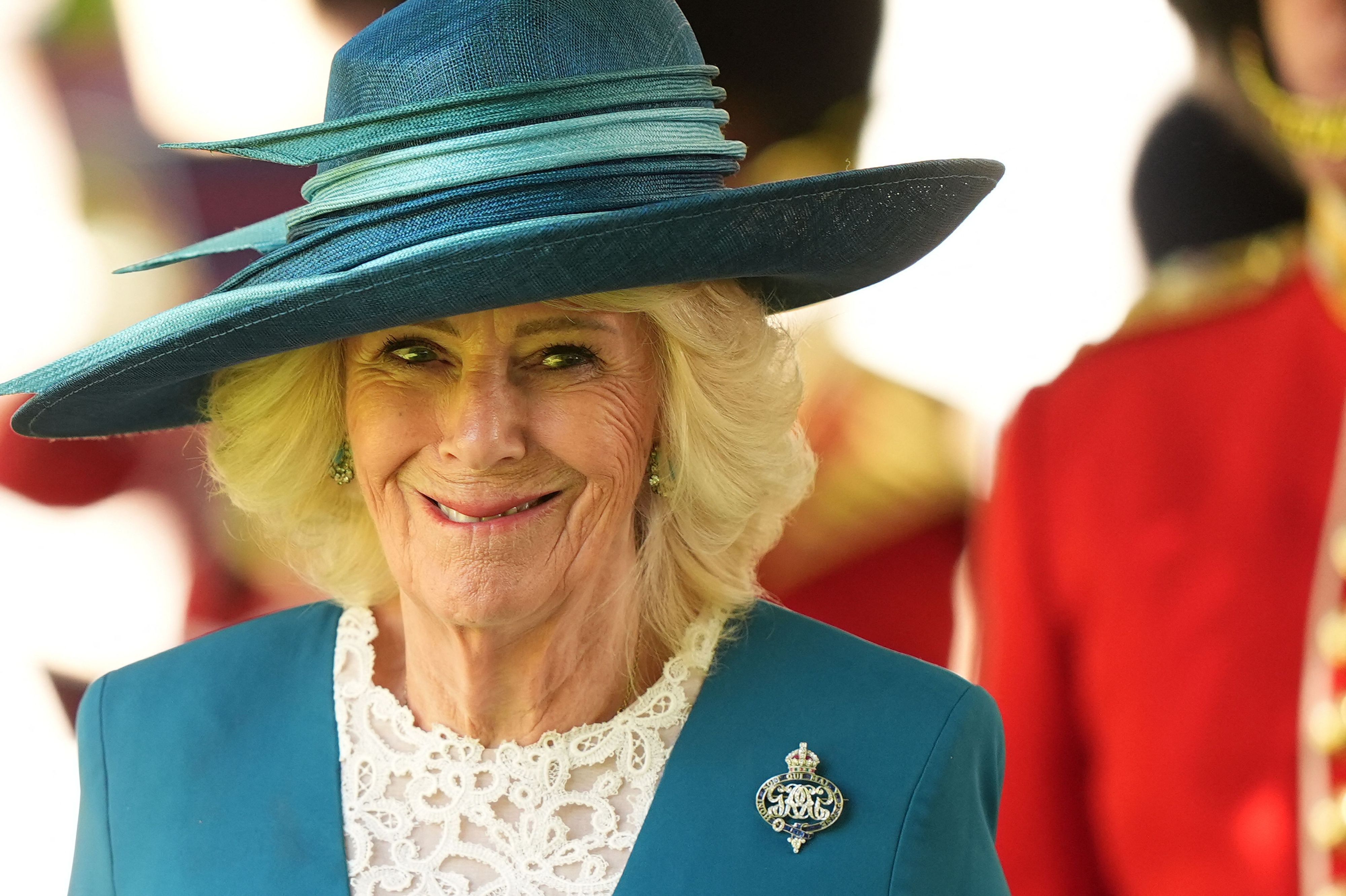 Königin Camilla in blauem Hut und Jacke.