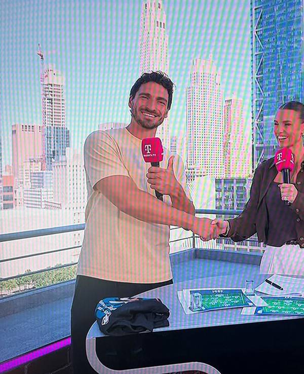 Mats Hummels und Laura Wontorra schütteln sich die Hand.