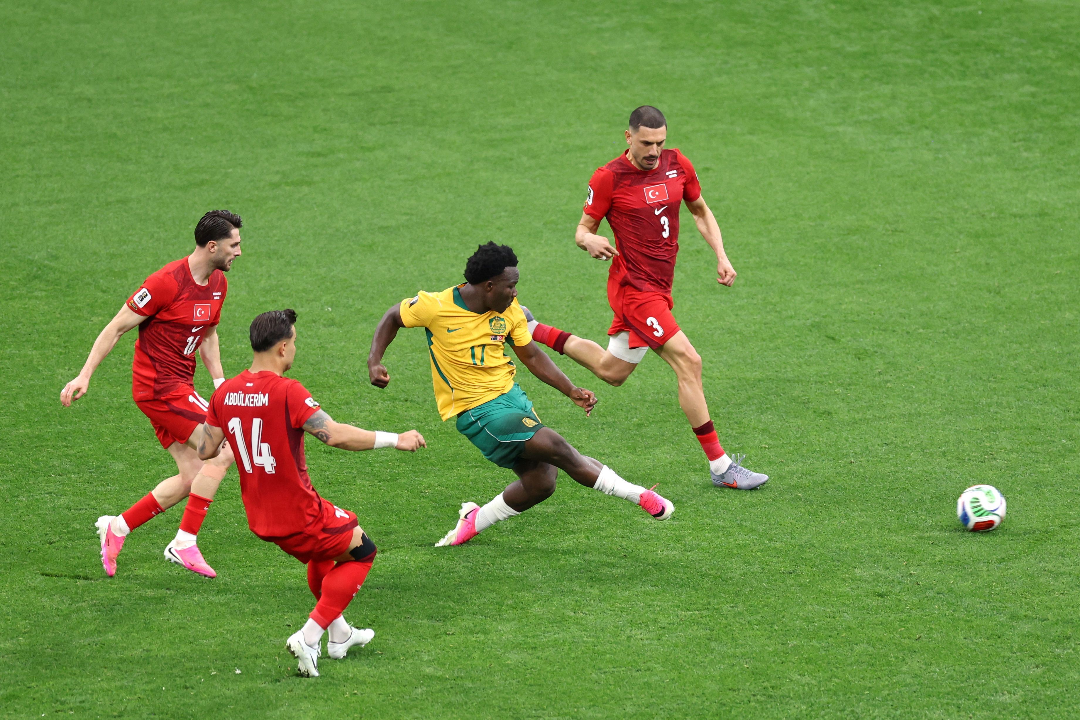 Der Australier Nestory Irankunda (2vr) erzielt das Tor zum 1:0. Drei türkische Spieler stehen um ihn herum.