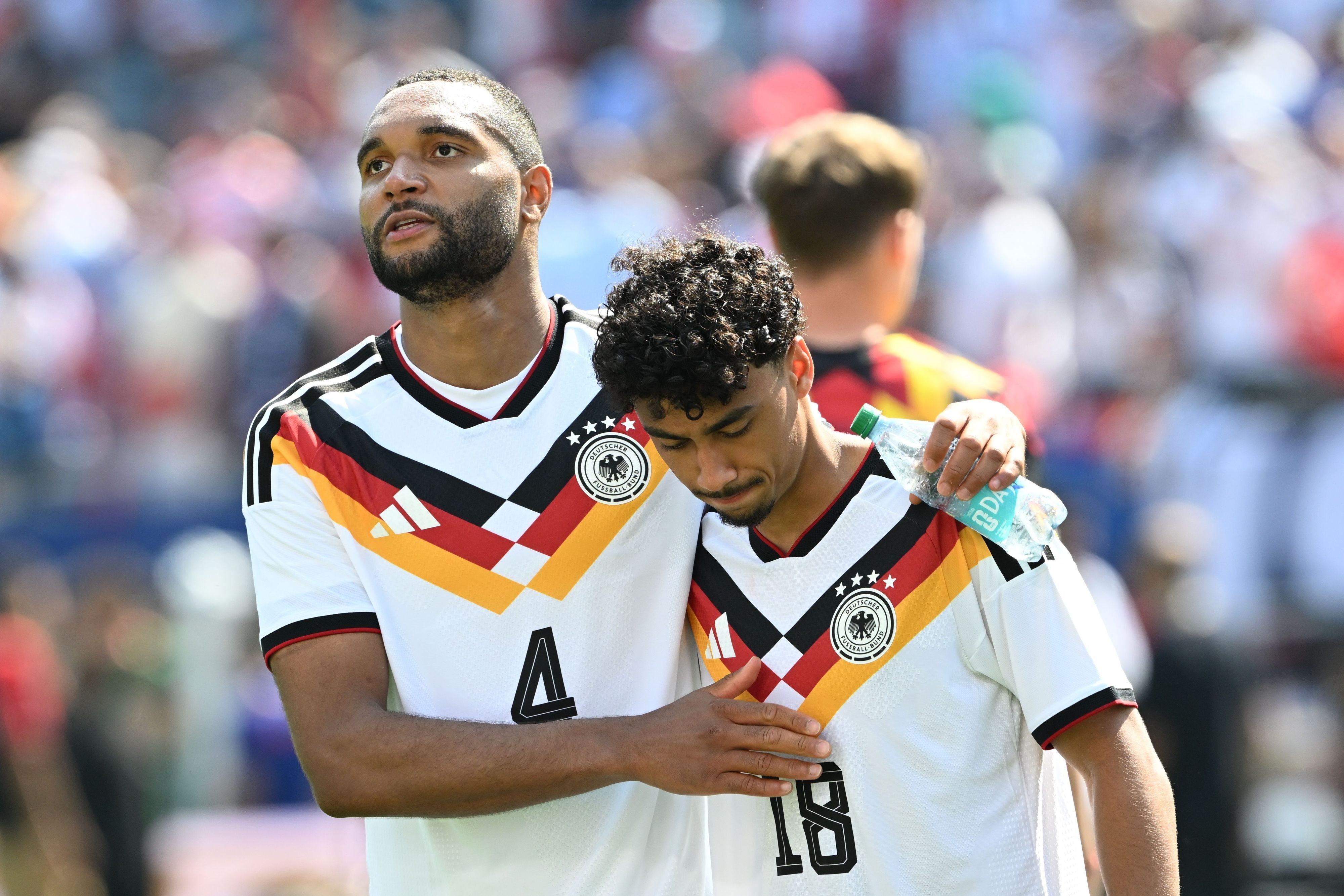 Jonathan Tah klopft Nathaniel Brown auf die Schulter.