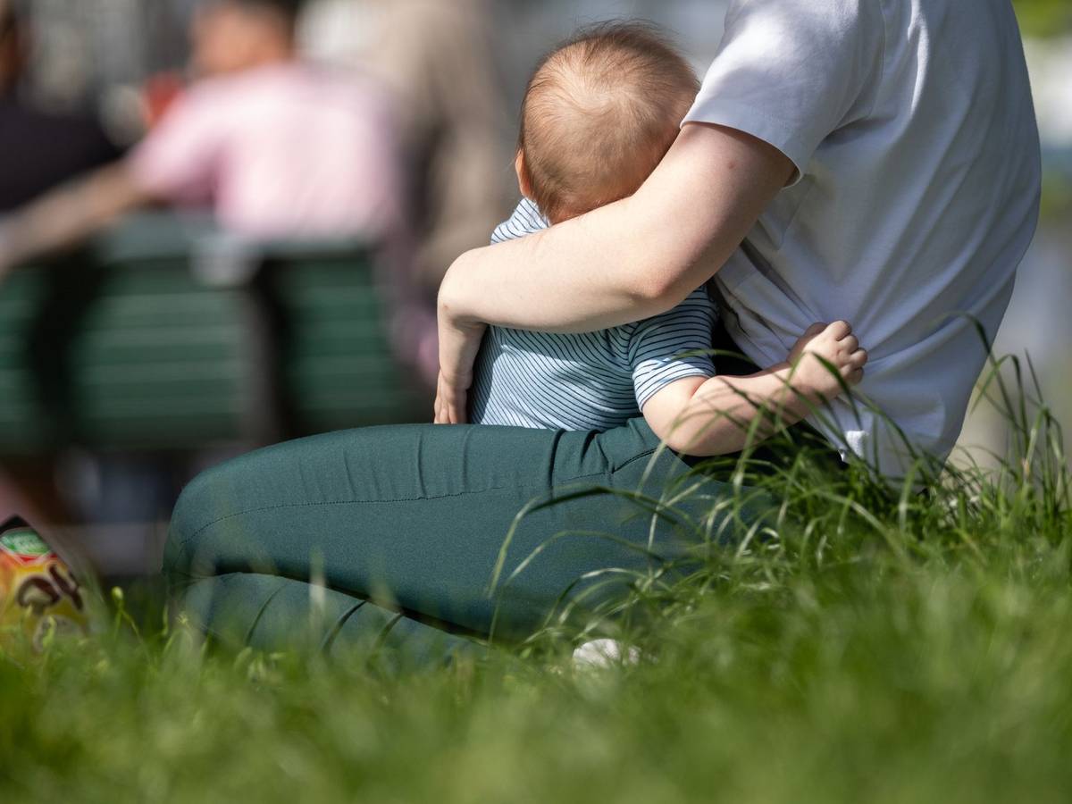 Eine Frau hält ein Kleinkind auf dem Arm