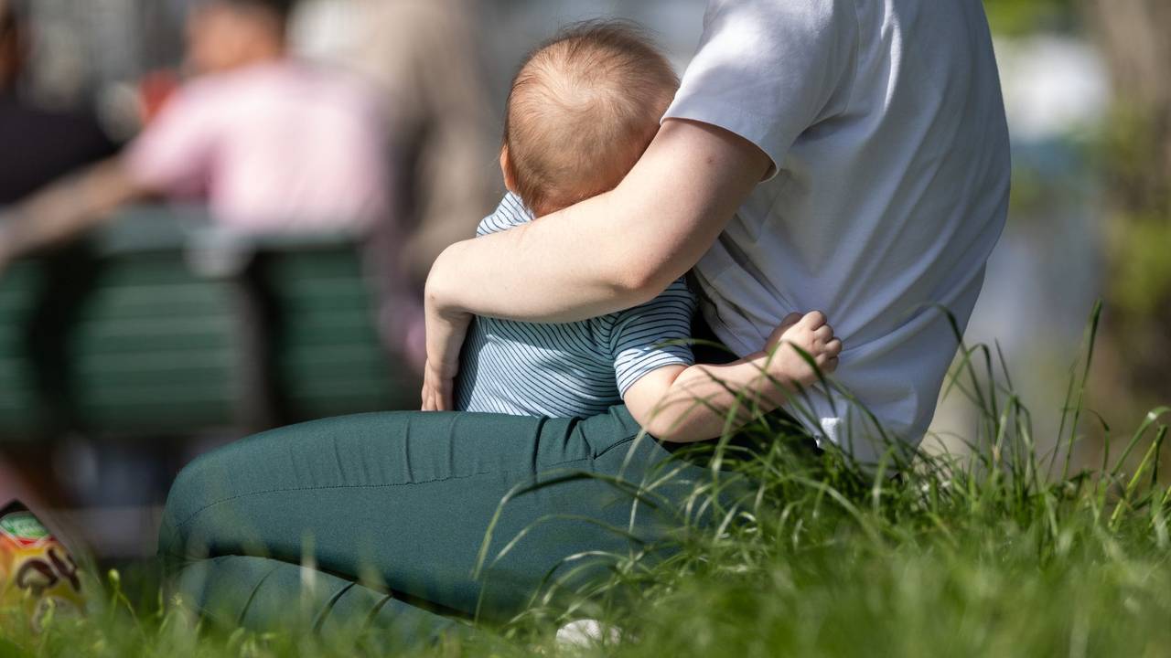 Eine Frau hält ein Kleinkind auf dem Arm