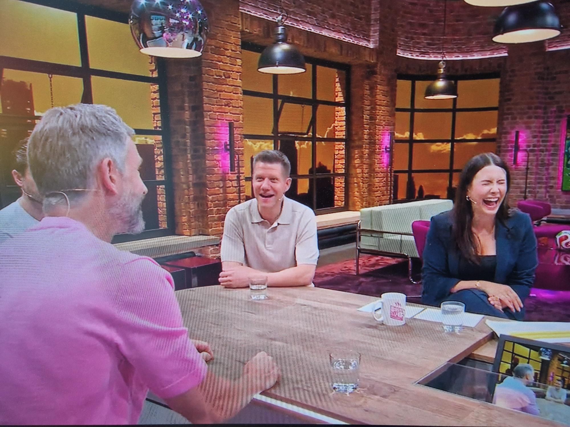 Laura Hofmann lacht im Breakfast Club von MagentaTV neben Patrick Ittrich und Micky Beisenherz.