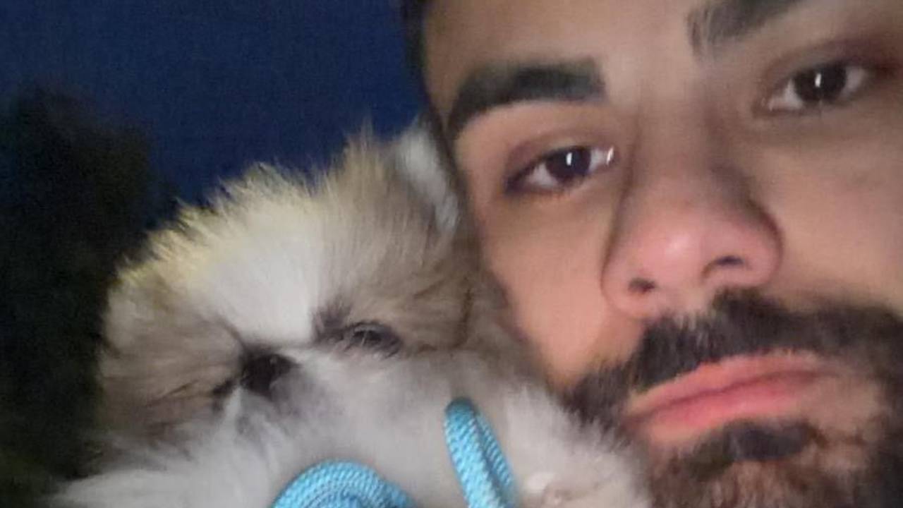 Renwar Mohamed drückt Welpe Pino an sein Gesicht.