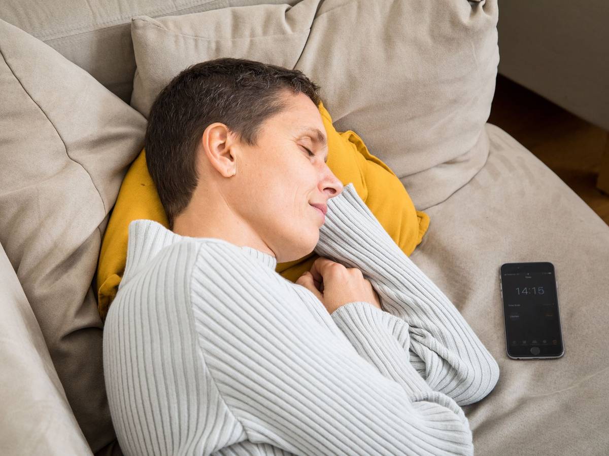Eine Frau schläft auf einem Sofa