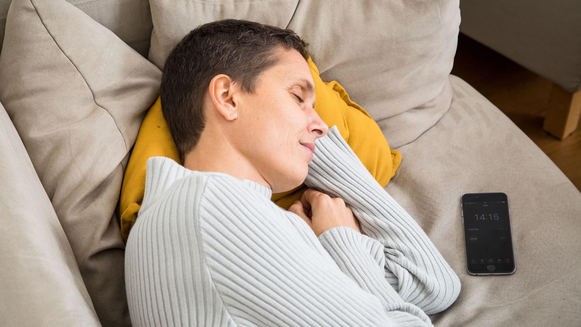 Eine Frau schläft auf einem Sofa