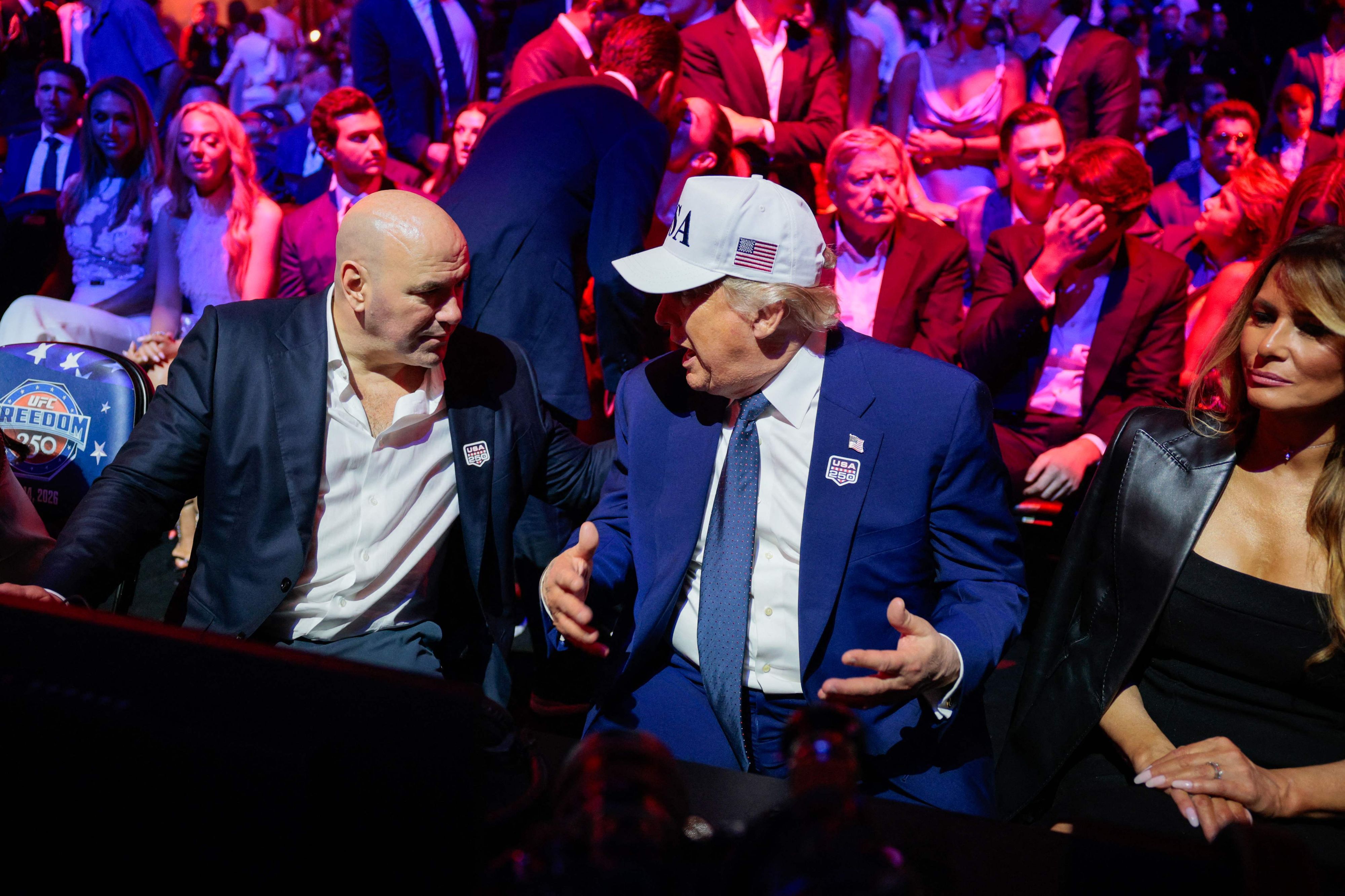 Donald Trump plaudert mit UFC-CEO Dana White (l.) während des UFC Freedom 250. First Lady Melanie Trump sitzt eher teilnahmelos daneben.