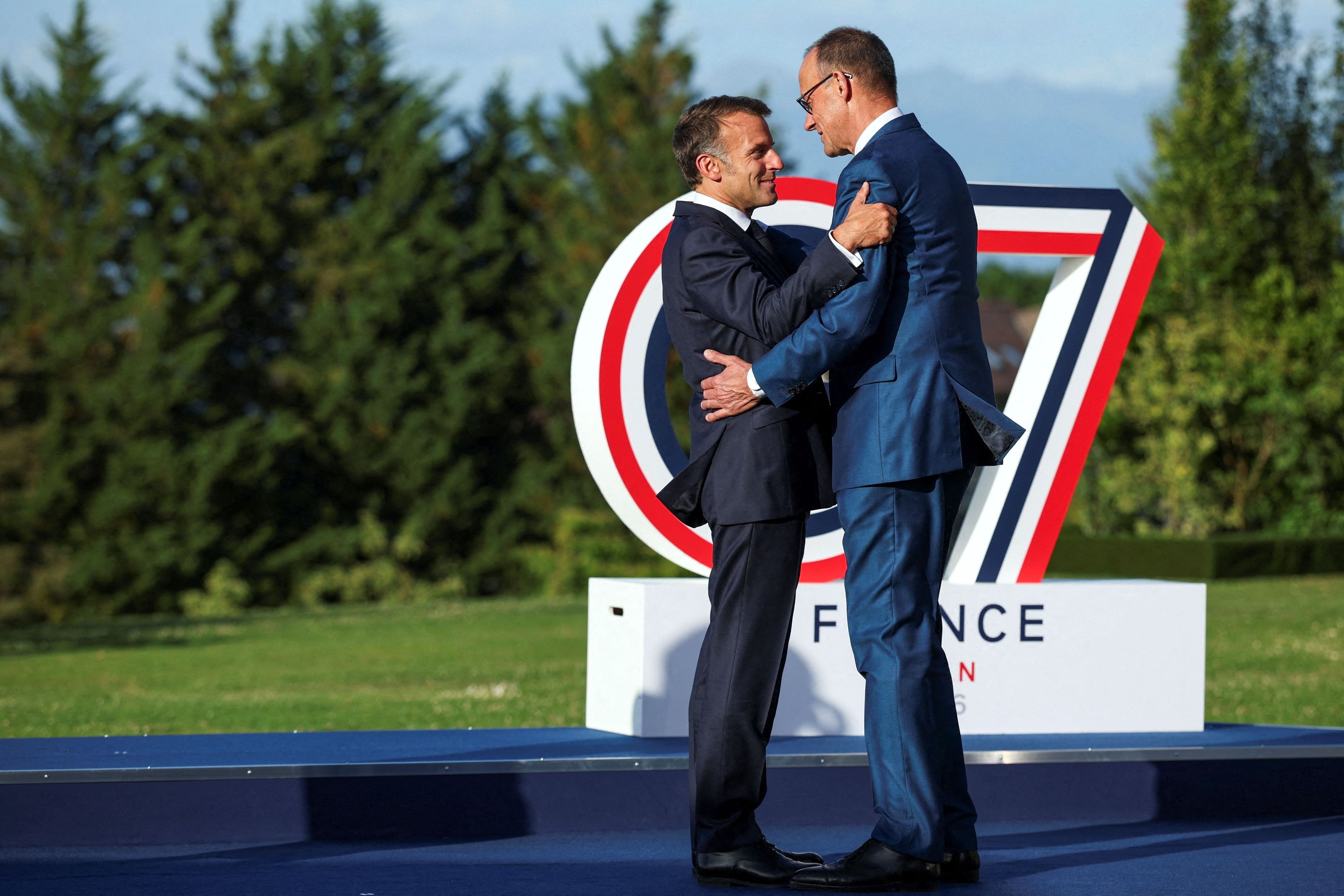 Frankreichs Präsident Emmanuel Macron (l.) begrüßt Bundeskanzler Friedrich Merz beim G7-Gipfel.