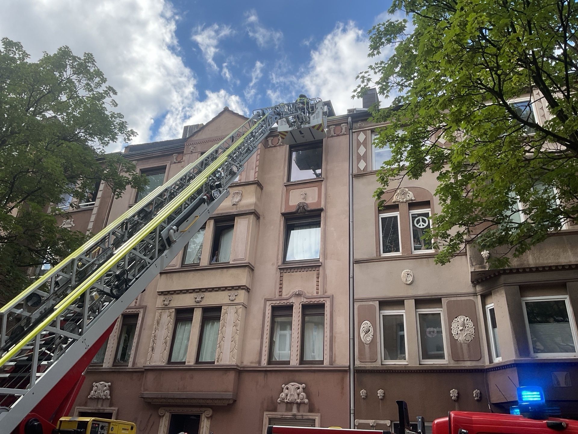 Nachdem ein vierjähriges Kind sich unbemerkt Zutritt zum Dach eines Mehrfamilienhauses verschafft hatte, ist die Feuerwehr mit einer Drehleiter im Einsatz.