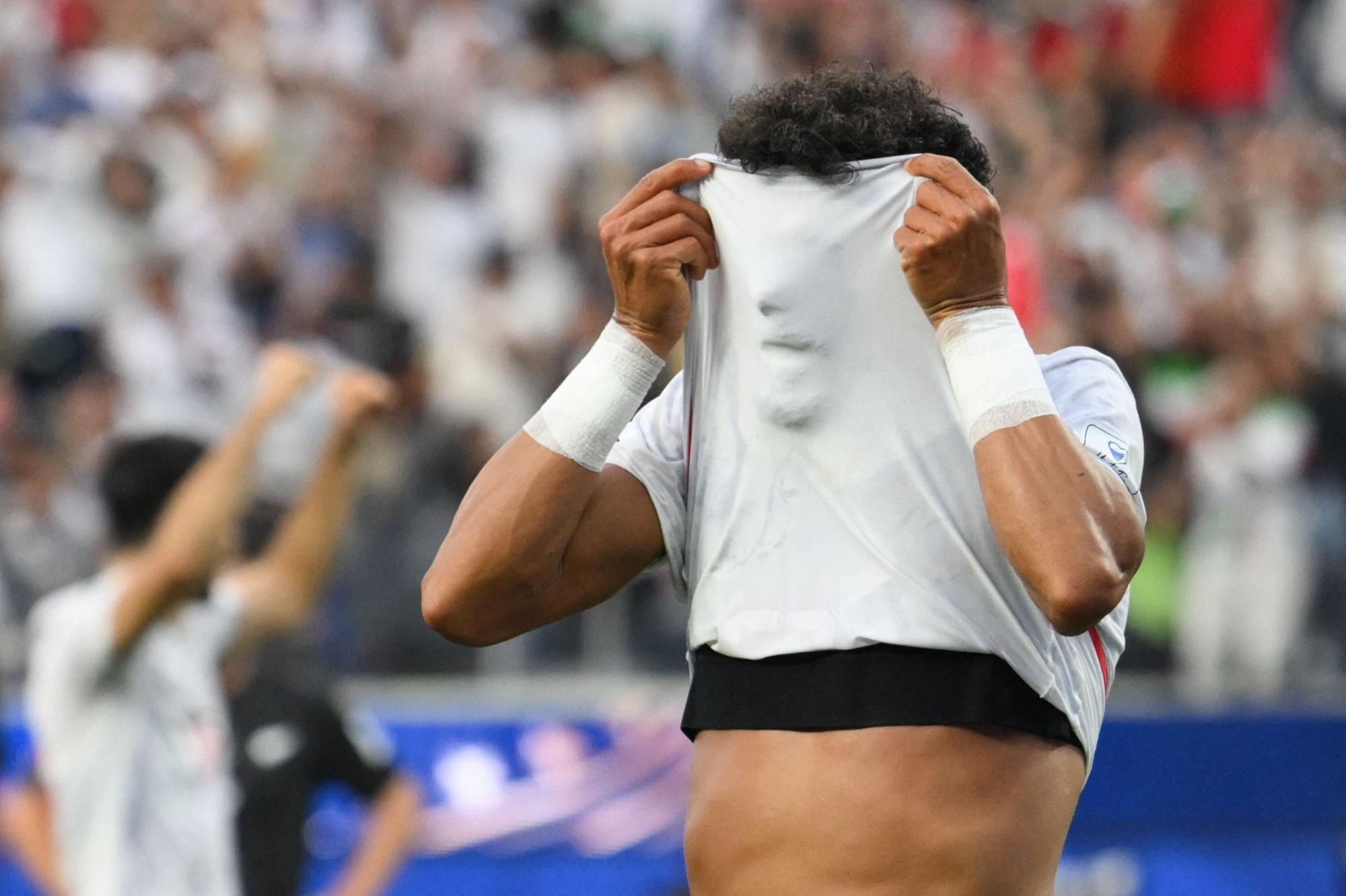 Iran-Verteidiger Ramin Rezaeian versteckt sein Gesicht beim Jubeln unter dem Trikot.