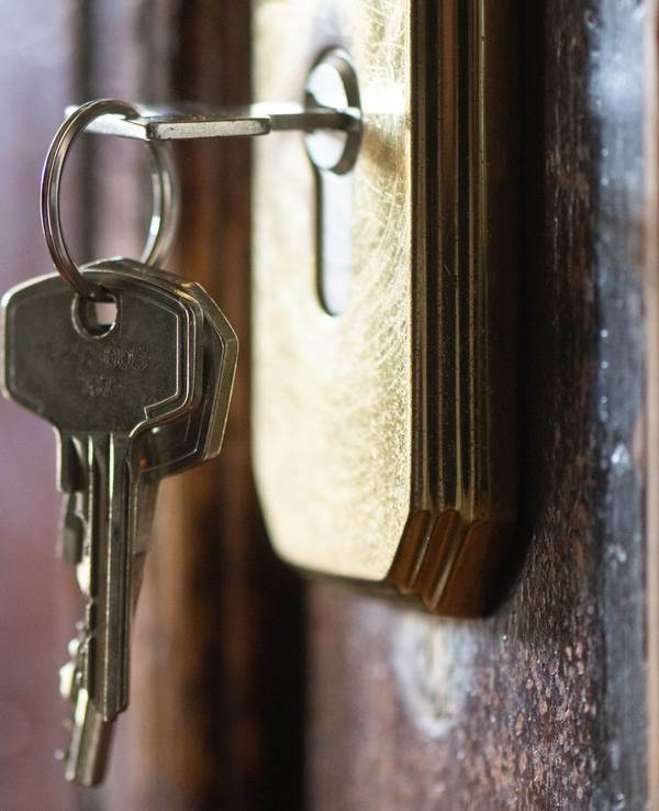 Ein Schlüssel steckt im Schloss einer Wohnungstür