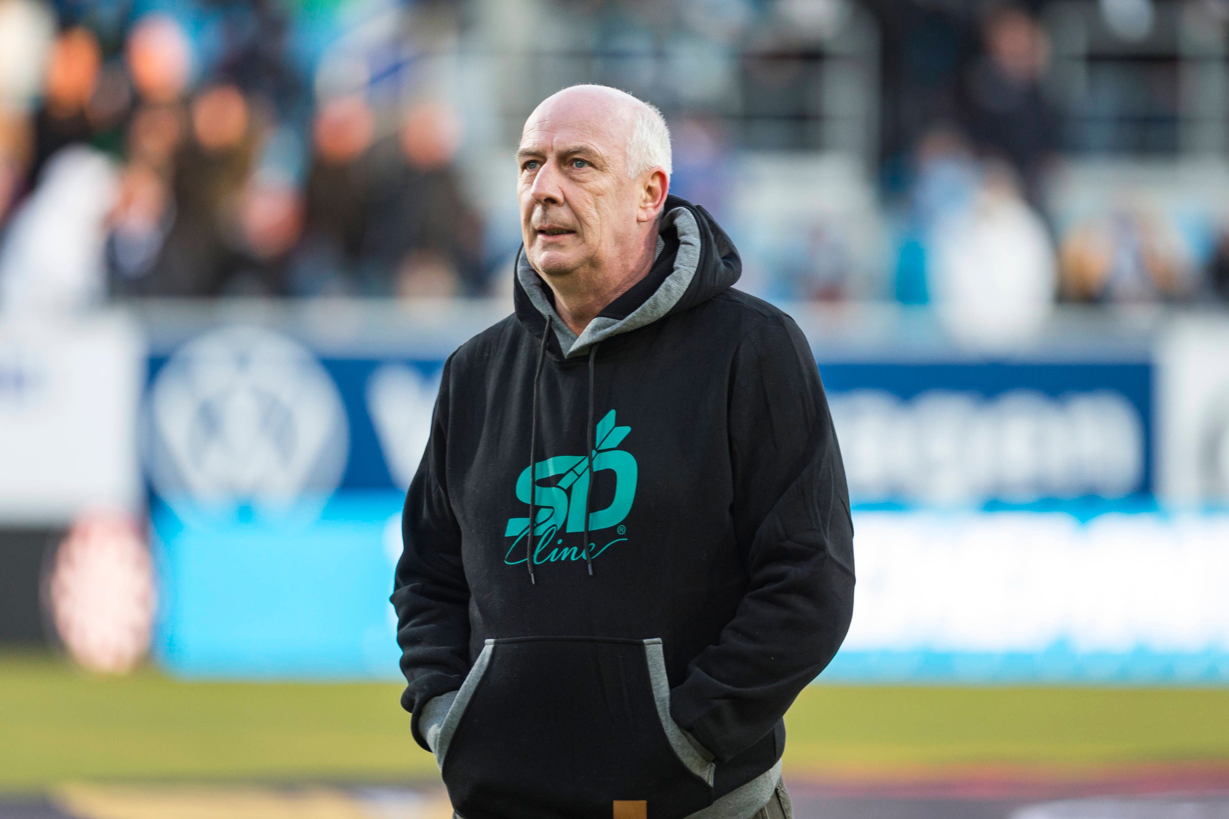 Mario Basler mit schwarzem Hoodie bekleidet bei einem Spiel.