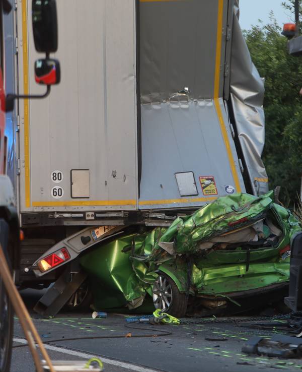 Ein zerquetschtes Auto steckt unter einem Sattelzug.