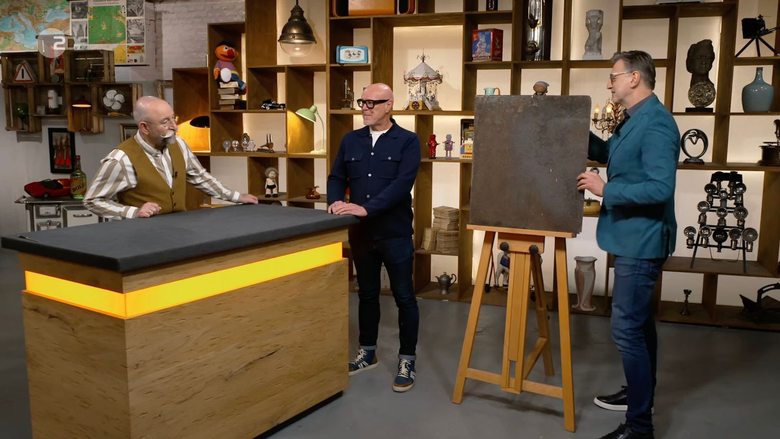 Detlev Kümmel (rechts) präsentierte zunächst die stark verwitterte Rückseite des alten Werbeschilds. (Bild: ZDF)