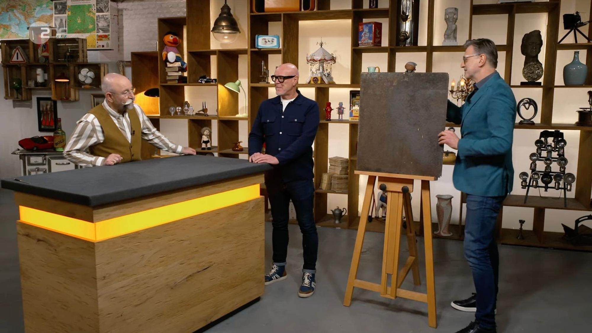 Detlev Kümmel (rechts) präsentierte zunächst die stark verwitterte Rückseite des alten Werbeschilds. (Bild: ZDF)
