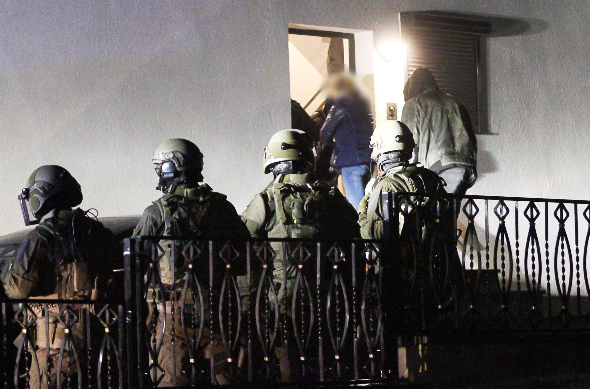 Polizeibeamte und Mitglieder eines Spezialeinsatzkommandos (SEK) betreten ein Haus.