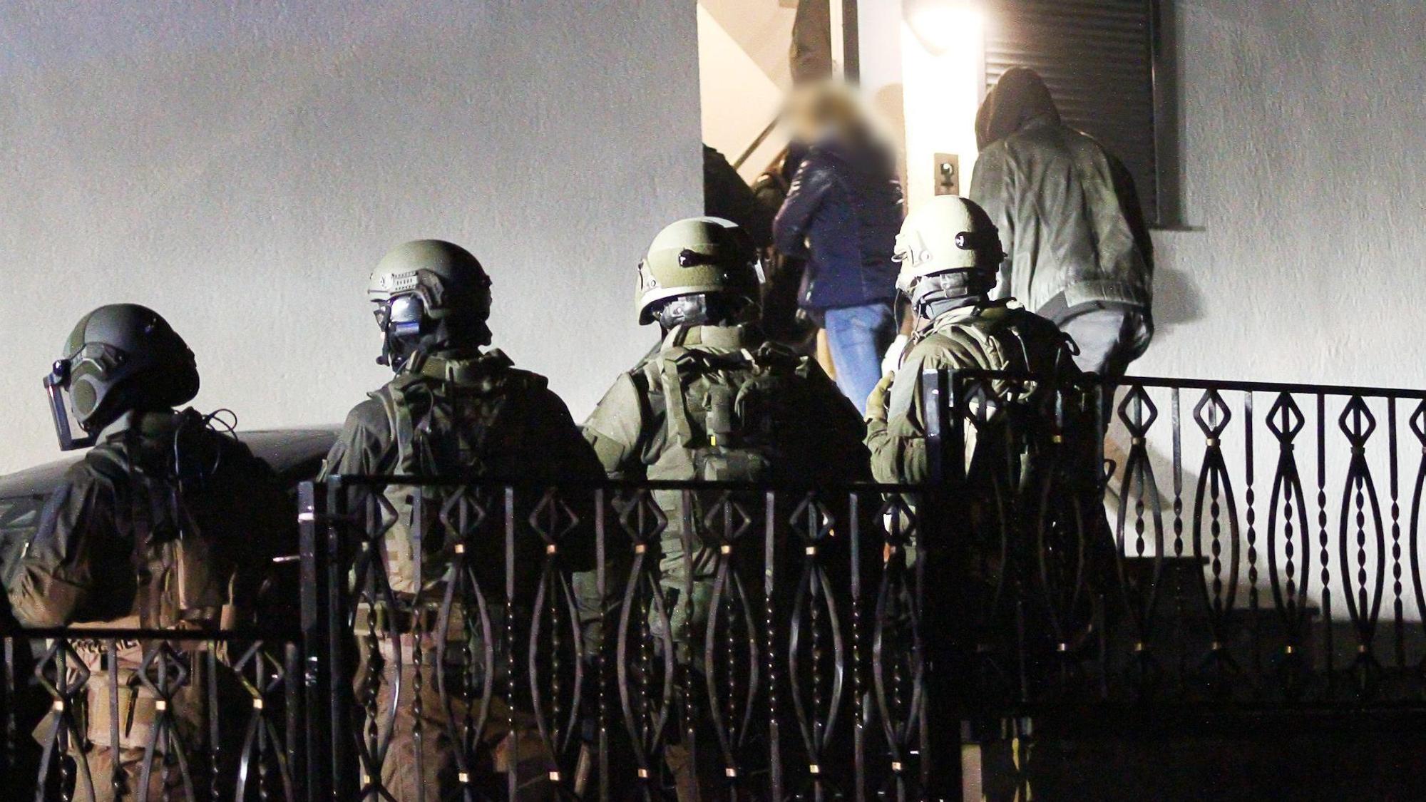 Polizeibeamte und Mitglieder eines Spezialeinsatzkommandos (SEK) betreten ein Haus.