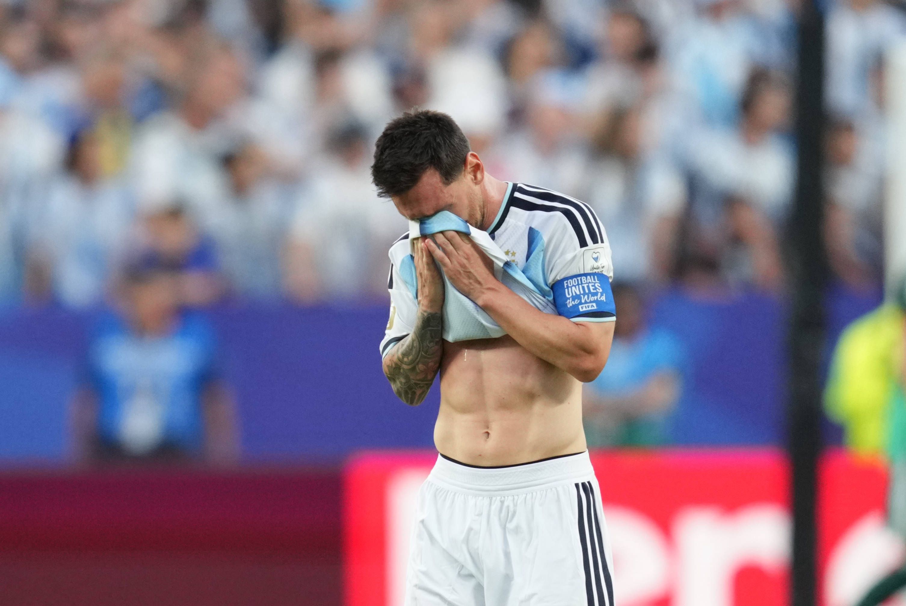 Lionel Messi wischt sich Tränen mit seinem Trikot weg.