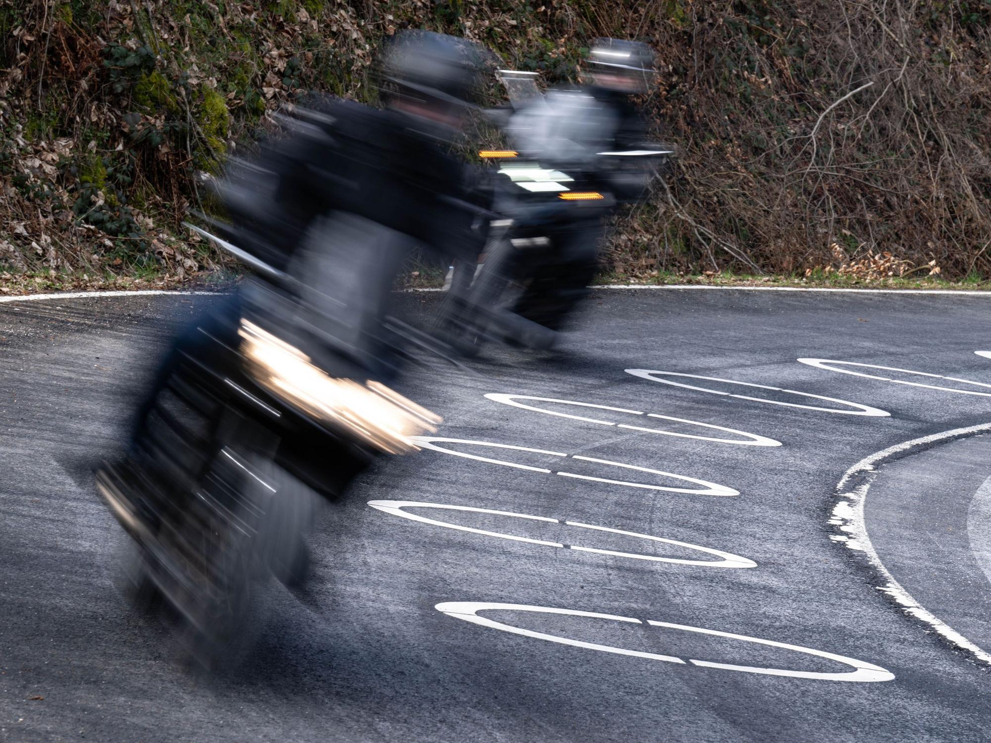 Motorradfahrer durchfahren die mit Ellipsen markierte Kurve des Verkehrsversuches bei der Eröffnung der Motorradsaison.