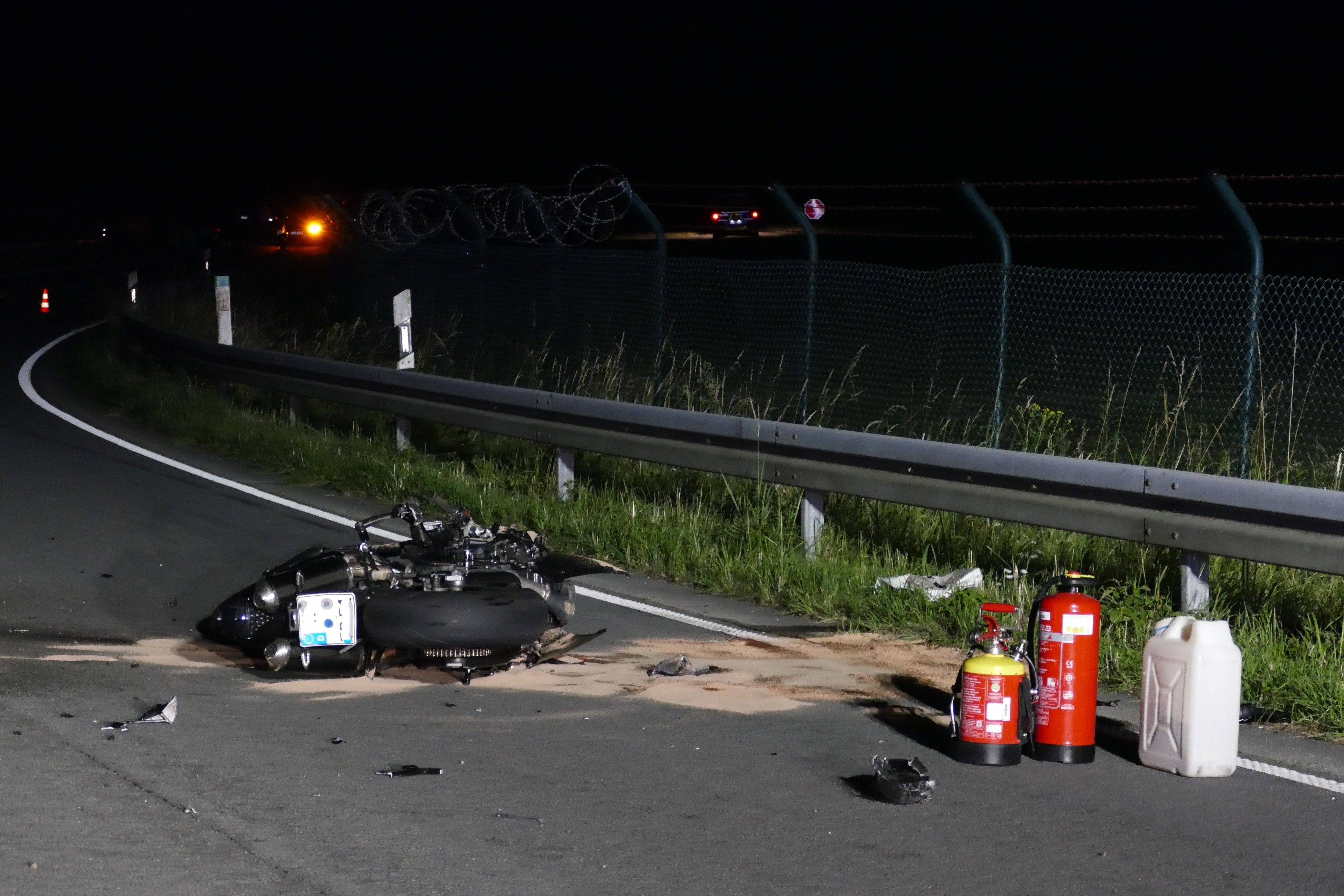 Trümmer des Motorrads liegen auf der Fahrbahn.