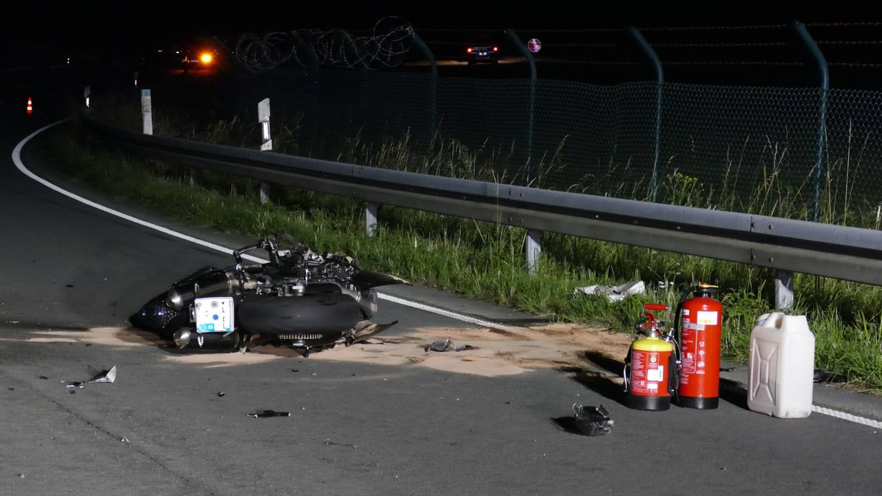 Trümmer des Motorrads liegen auf der Fahrbahn.