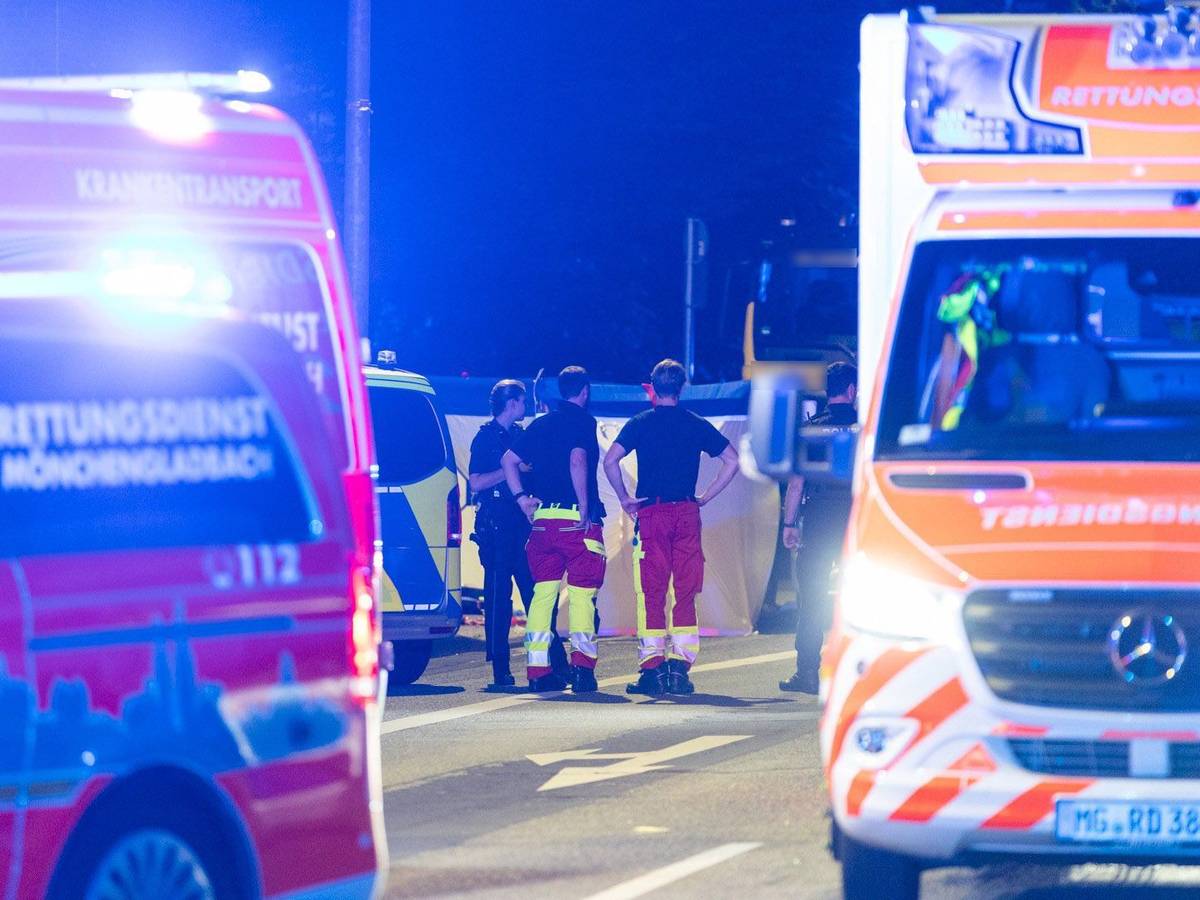 Einsatzkräfte stehen zusammen auf der Straße. Bei einem Polizeieinsatz an einer Tankstelle in Mönchengladbach hat die Polizei auf eine 18-Jährige geschossen, die den Angaben zufolge ein Messer mitführte.