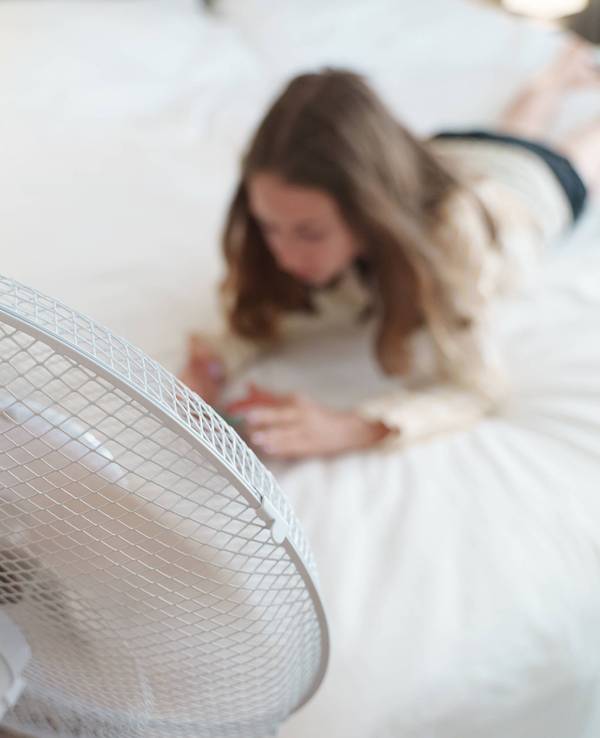 Ein Teenager liegt mit dem Telefon vor einem Ventilator. Teenager lies with the phone in front of cooling fan. LicenseRF ,model released, Symbolfoto Copyright: xZoonar.com/DmitrixMarutax 23318255 ,model released, Symbolfoto ,property released