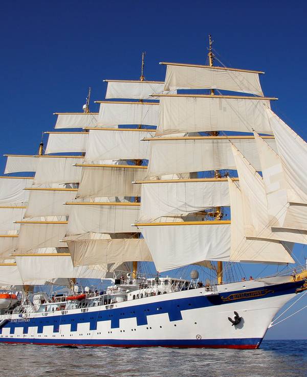Ein Segelschiff mit fünf Masten und weißen Segeln