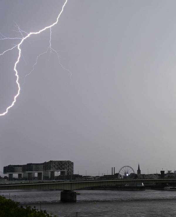 Ein Blitz zuckt bei einem Gewitter über dem Himmel über dem Kölner Süden (Archivbild).