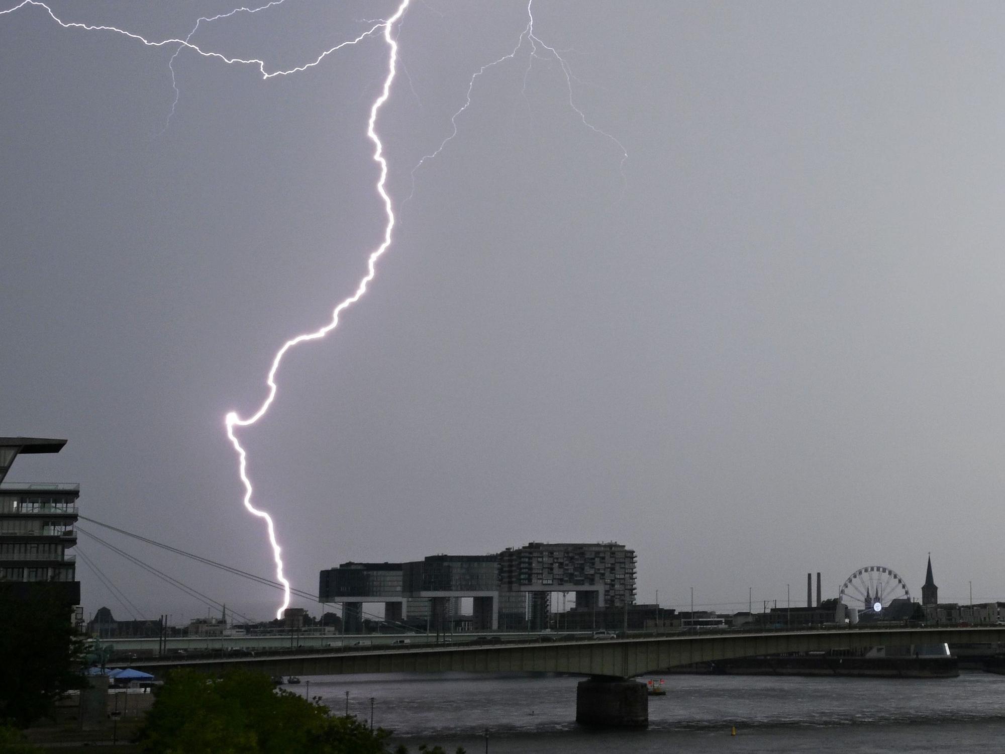Ein Blitz zuckt bei einem Gewitter über dem Himmel über dem Kölner Süden (Archivbild).