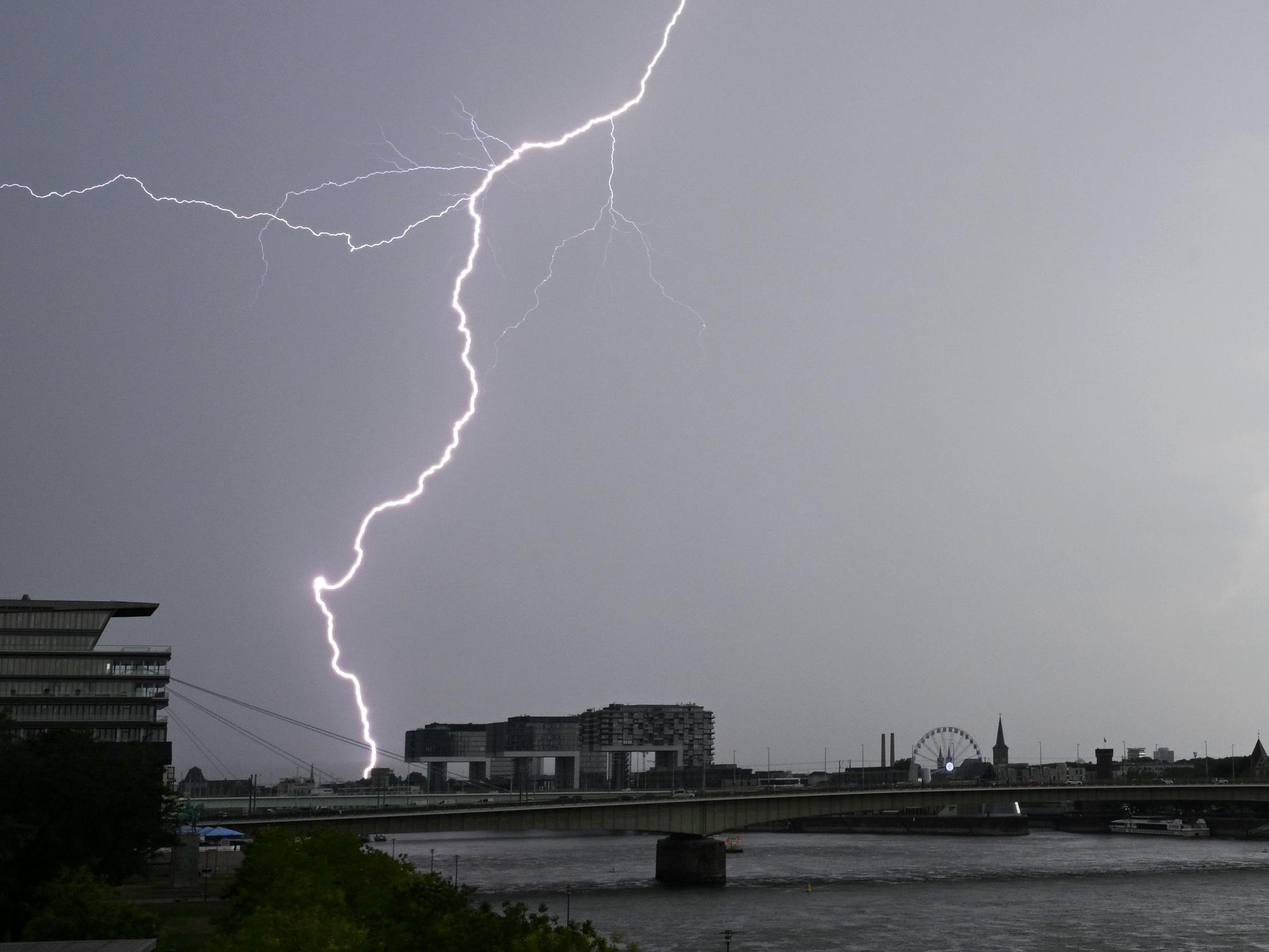 Ein Blitz zuckt bei einem Gewitter über dem Himmel über dem Kölner Süden (Archivbild).