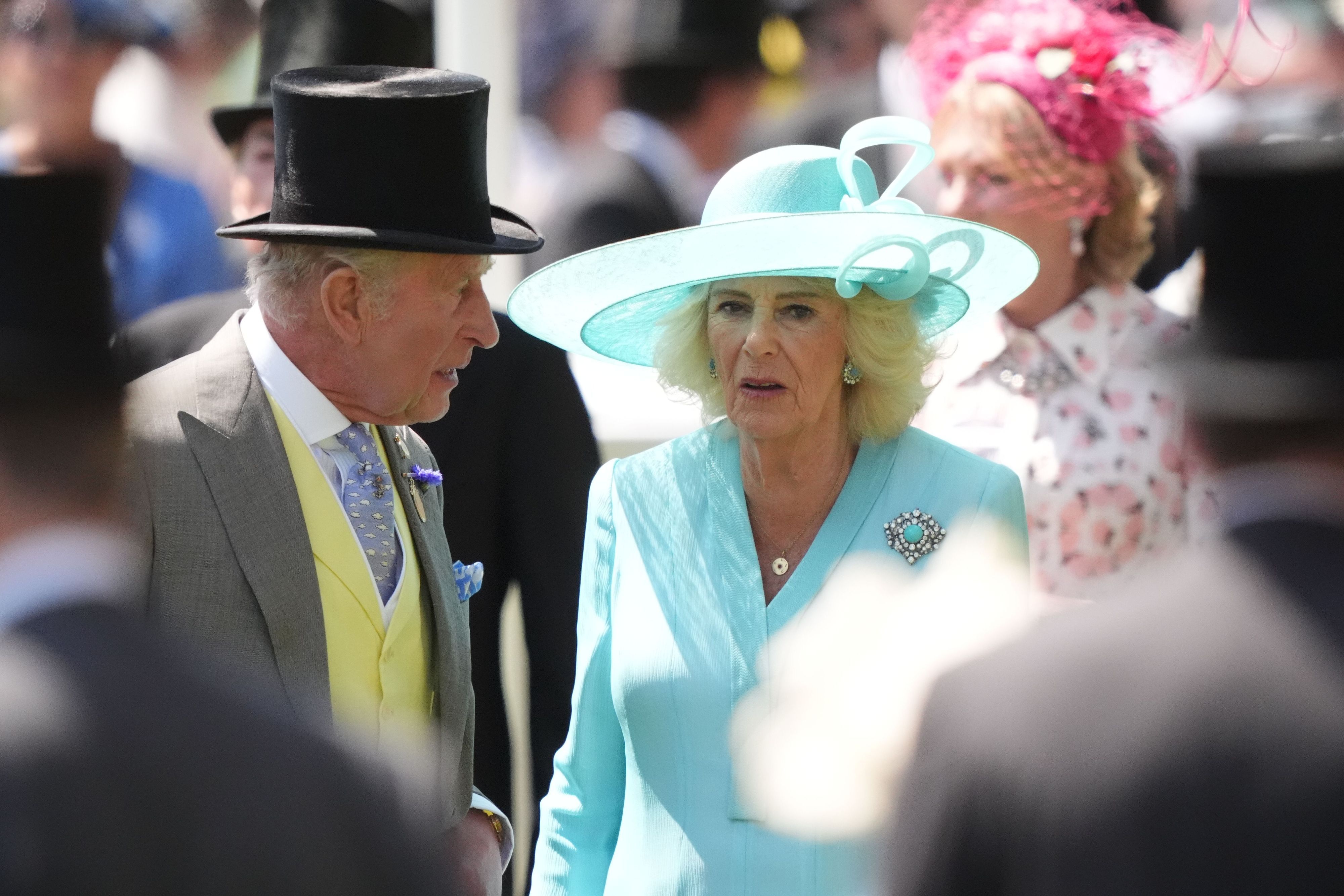 König Charles III. (l) und Königin Camilla fahren mit einer Kutsche am vierten Tag des Ascot Pferderennens an der Rennstrecke vor.