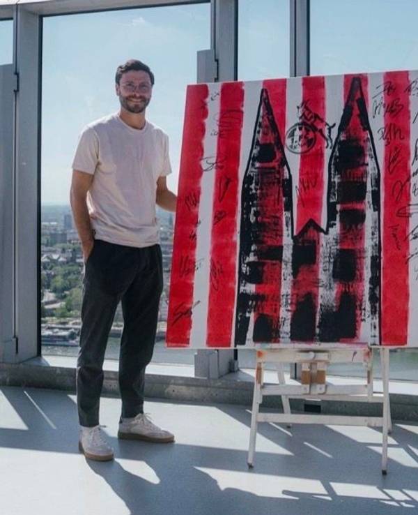Der 13-jährige Künstler Mikail Akar und Jonas Hector mit dem FC-Kunstwerk in Köln.
