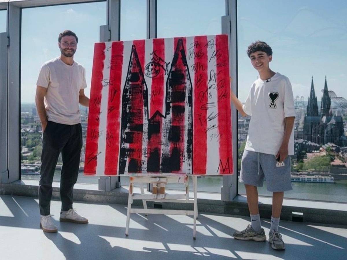 Der 13-jährige Künstler Mikail Akar und Jonas Hector mit dem FC-Kunstwerk in Köln.